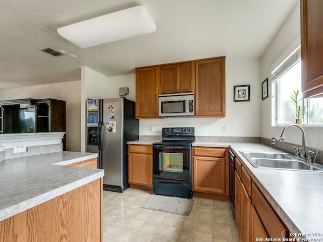 kitchen with a textured ceiling, sink, and black appliances