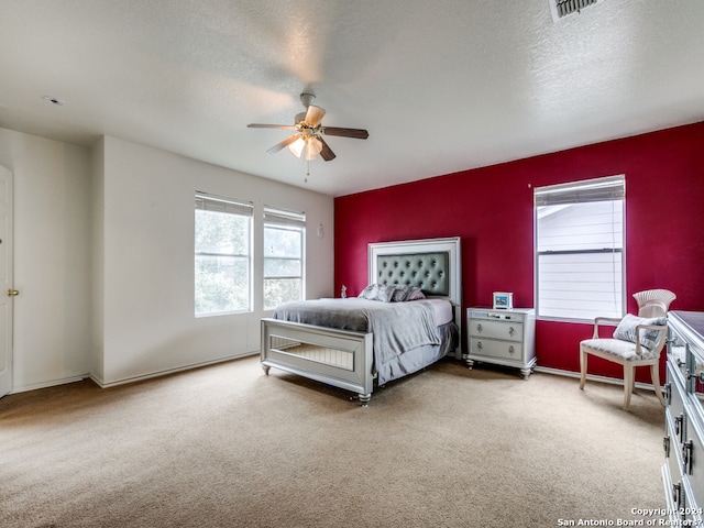 bedroom with carpet, ceiling fan, and a textured ceiling