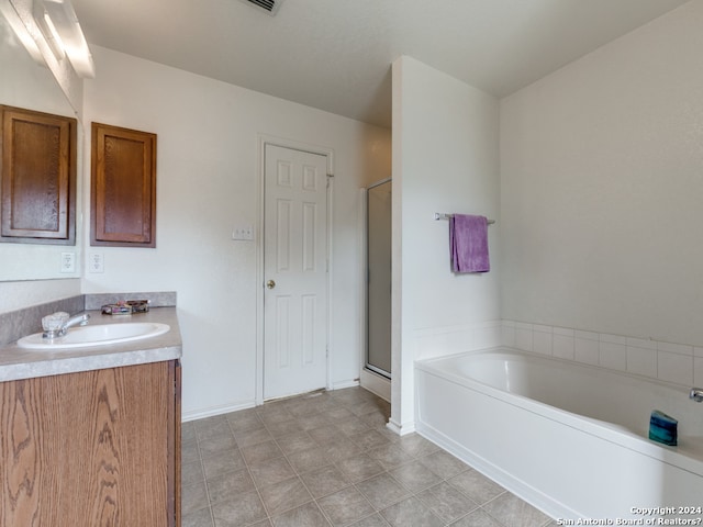 bathroom with tile patterned floors, vanity, and plus walk in shower