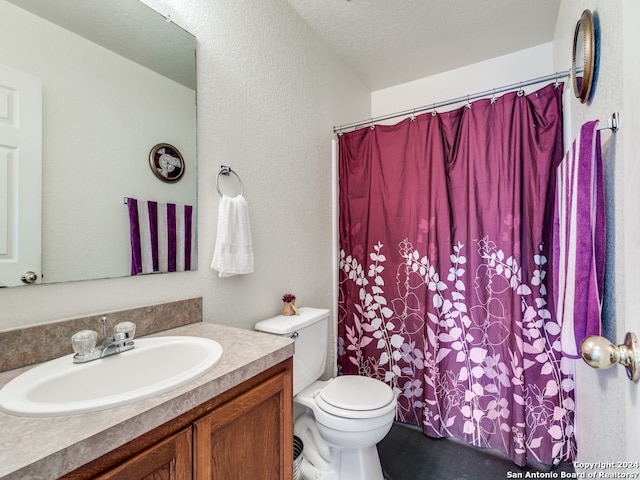 bathroom with vanity, toilet, and a textured ceiling