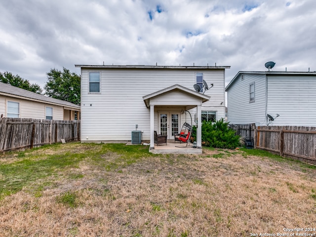 rear view of property with a lawn, a patio area, french doors, and cooling unit