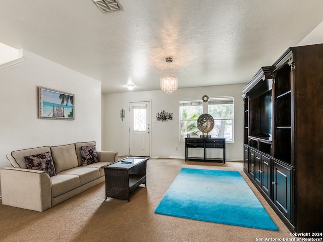 living room with carpet flooring, a textured ceiling, and an inviting chandelier