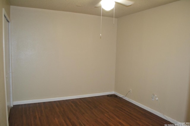 unfurnished room featuring ceiling fan, dark hardwood / wood-style flooring, and a textured ceiling