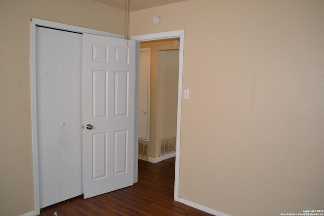 unfurnished bedroom featuring dark hardwood / wood-style floors and a closet