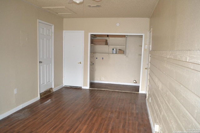 unfurnished room featuring a textured ceiling and dark hardwood / wood-style floors