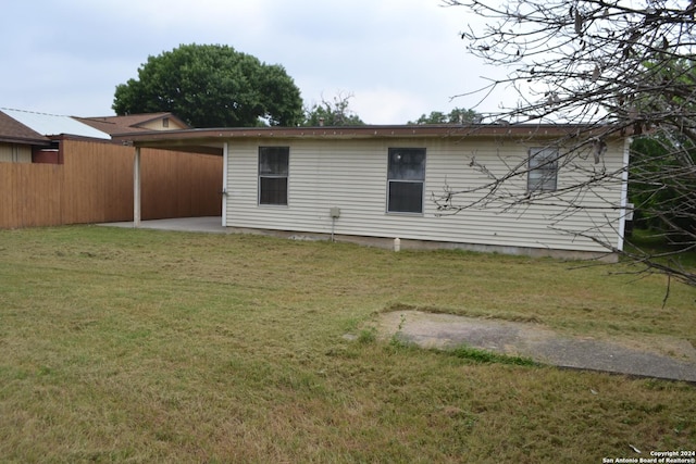 rear view of house featuring a yard and a patio