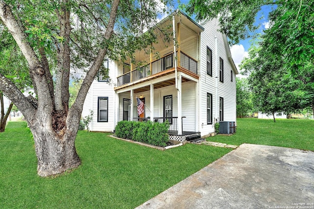 view of front of home with a balcony, covered porch, and a front yard