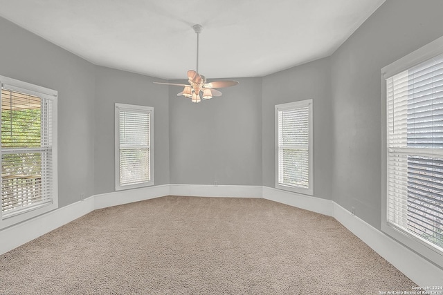 unfurnished room with carpet flooring, plenty of natural light, and ceiling fan