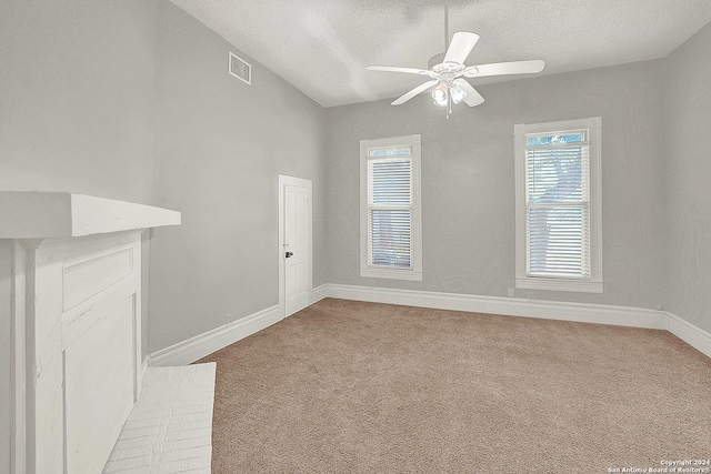 carpeted empty room with ceiling fan and a textured ceiling