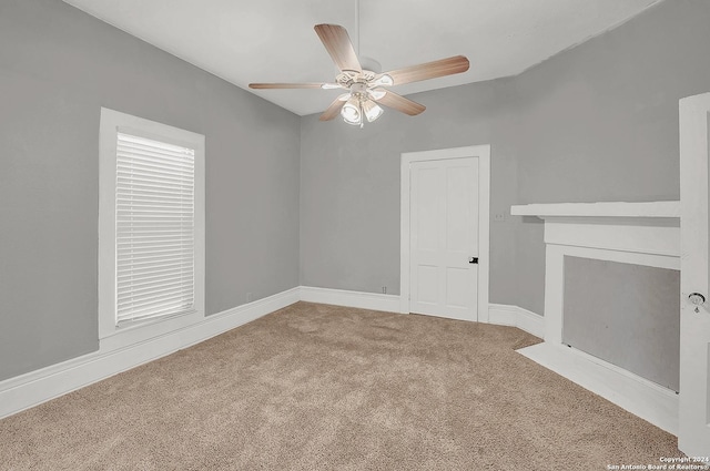 unfurnished living room featuring ceiling fan and carpet floors