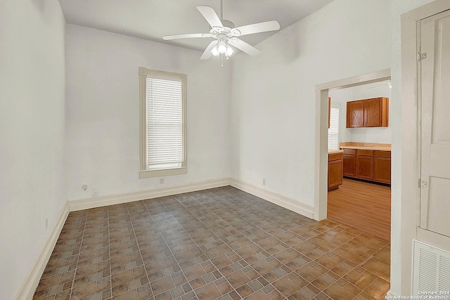 spare room featuring ceiling fan, dark wood-type flooring, and a wealth of natural light