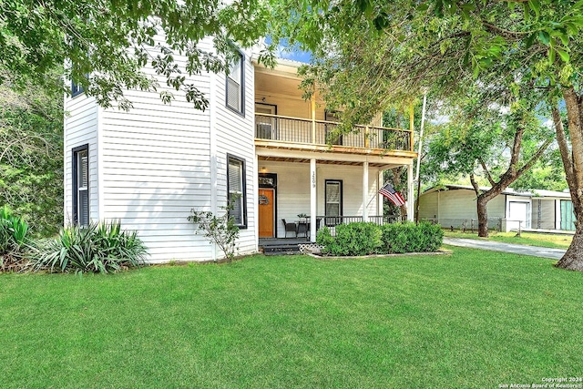 view of front facade featuring a balcony, a front lawn, and a porch