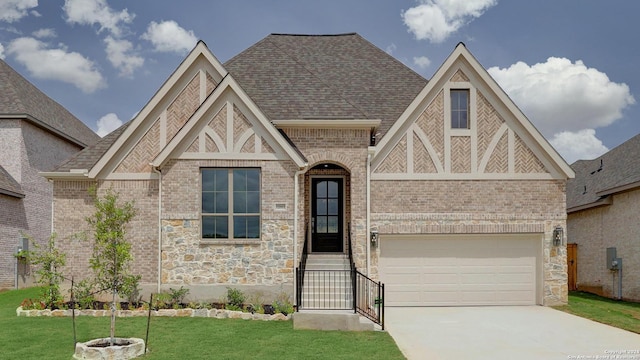 english style home with a front yard and a garage