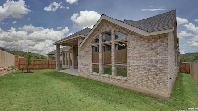 back of house with a yard and a patio