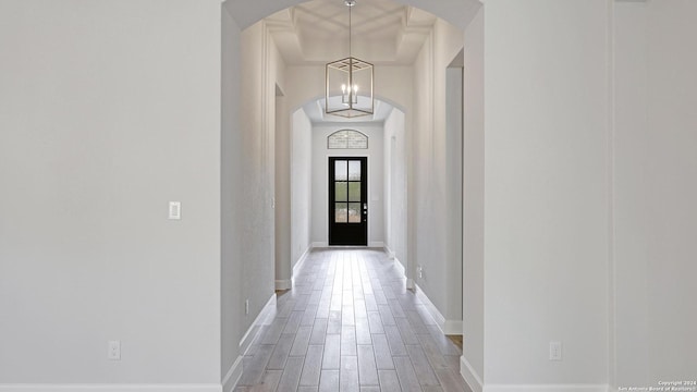 hallway featuring hardwood / wood-style floors and a chandelier