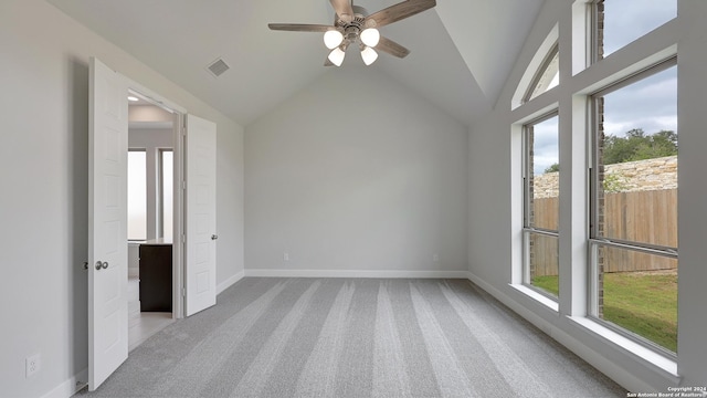 spare room featuring light carpet, high vaulted ceiling, and ceiling fan