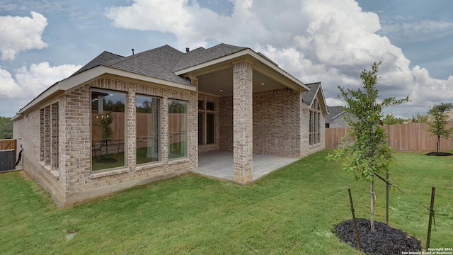 back of property with a yard and a patio