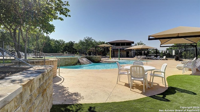 view of pool with pool water feature and a patio