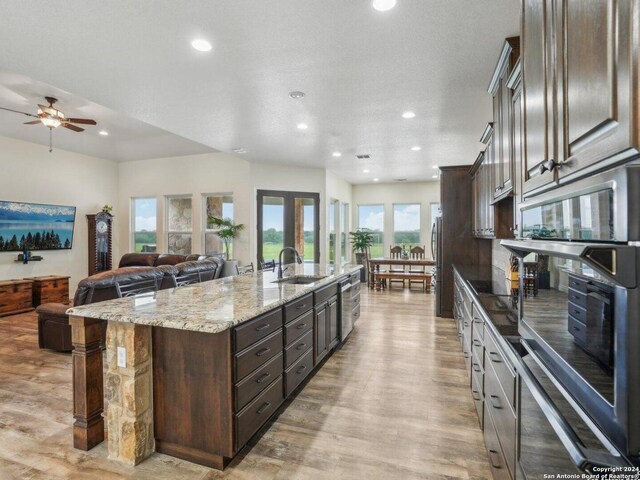 7803 US Highway 181, Falls City, TX 78113 - kitchen with a sink, light wood-style flooring, a large island, dark brown cabinets, and recessed lighting