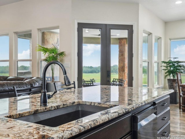 7803 US Highway 181, Falls City, TX 78113 - kitchen with a sink, light stone countertops, french doors, recessed lighting, and wood finished floors