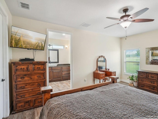 7803 US Highway 181, Falls City, TX 78113 - bedroom featuring wood finished floors, ensuite bath, ceiling fan, and baseboards