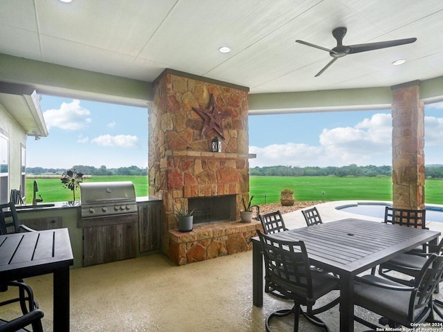7803 US Highway 181, Falls City, TX 78113 - view of patio featuring an outdoor stone fireplace, area for grilling, outdoor dining space, ceiling fan, and an outdoor kitchen
