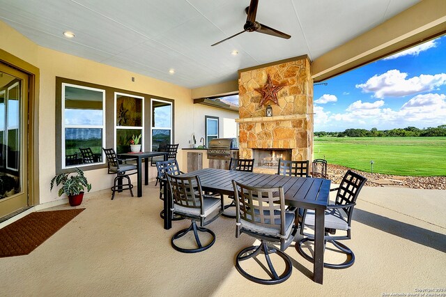 7803 US Highway 181, Falls City, TX 78113 - view of patio / terrace featuring outdoor dining area, an outdoor stone fireplace, ceiling fan, and grilling area