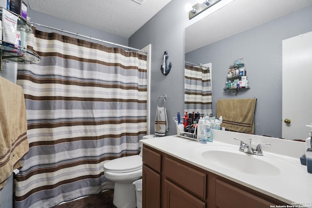 bathroom featuring vanity, a textured ceiling, and toilet