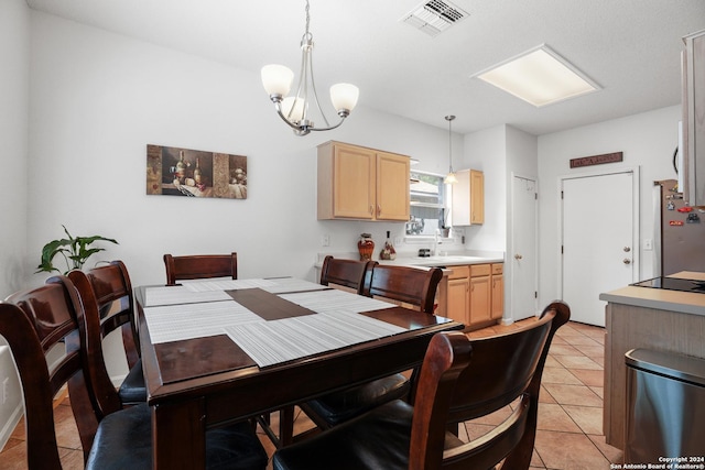 tiled dining space featuring sink and a notable chandelier