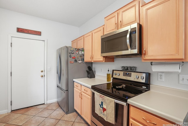 kitchen with appliances with stainless steel finishes, light brown cabinets, and light tile patterned floors