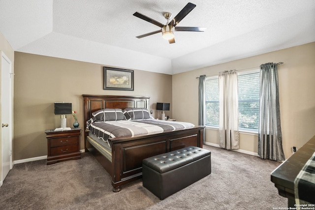 bedroom with a tray ceiling, ceiling fan, a textured ceiling, and dark colored carpet