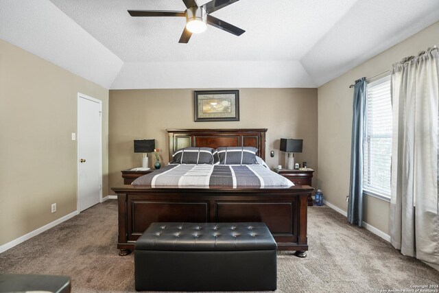 carpeted bedroom featuring ceiling fan, a raised ceiling, a textured ceiling, and vaulted ceiling