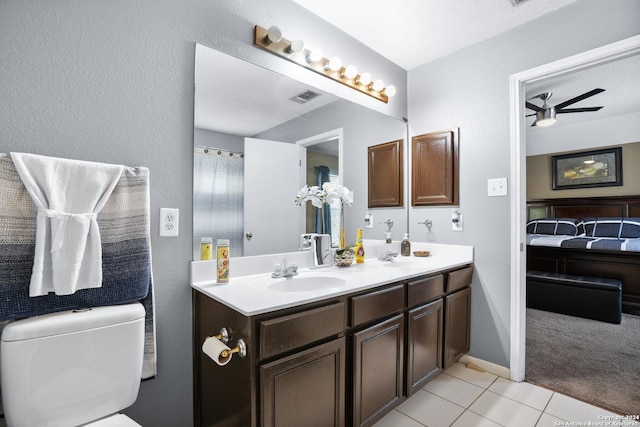 bathroom featuring a textured ceiling, vanity, ceiling fan, tile patterned flooring, and toilet