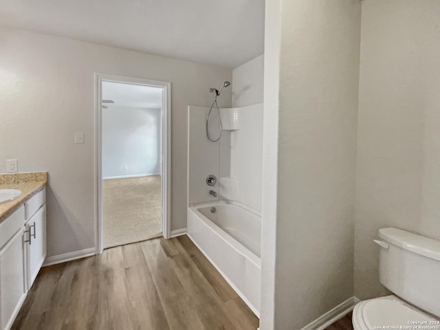 full bathroom with washtub / shower combination, toilet, vanity, and hardwood / wood-style flooring