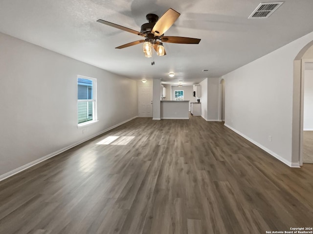 unfurnished living room featuring ceiling fan and dark hardwood / wood-style flooring