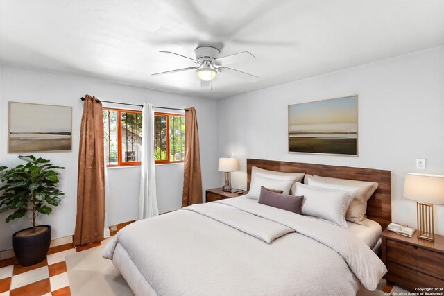 tiled bedroom featuring ceiling fan