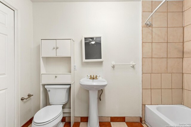 full bathroom featuring tile flooring, sink, tiled shower / bath combo, ceiling fan, and toilet