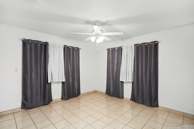 empty room with light tile patterned floors and a ceiling fan