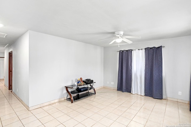 empty room with a ceiling fan, visible vents, baseboards, and light tile patterned floors