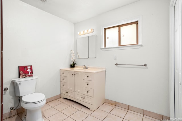 bathroom featuring tile flooring, vanity, and toilet