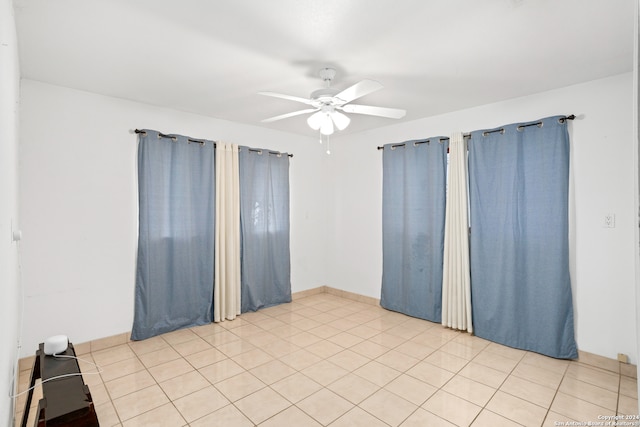 empty room with light tile flooring and ceiling fan