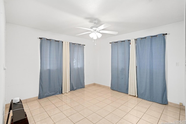 empty room featuring light tile patterned floors and ceiling fan