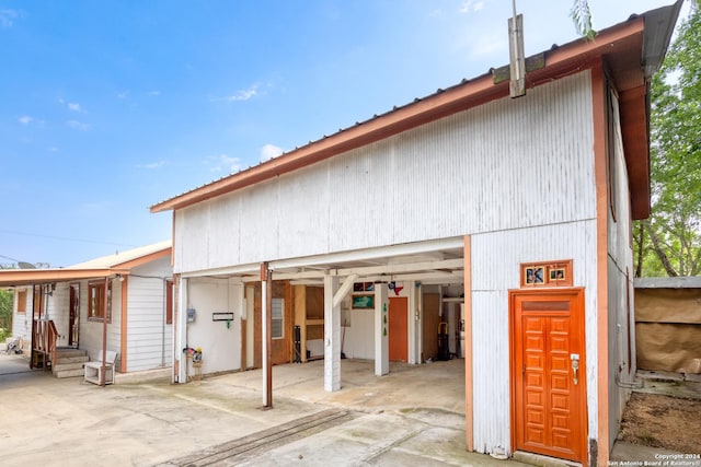 exterior space with a garage, metal roof, and an outbuilding