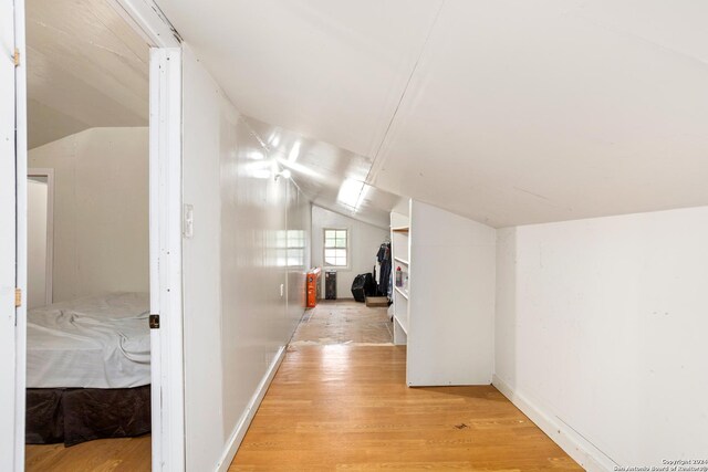 hall with light hardwood / wood-style floors and lofted ceiling