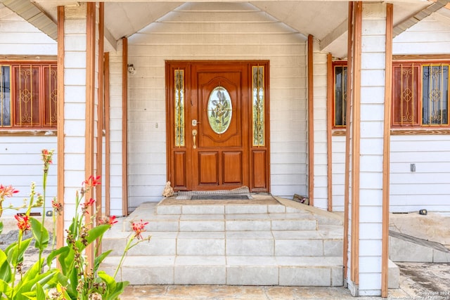 view of exterior entry featuring covered porch