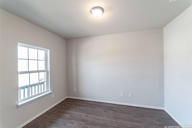 empty room with dark hardwood / wood-style flooring