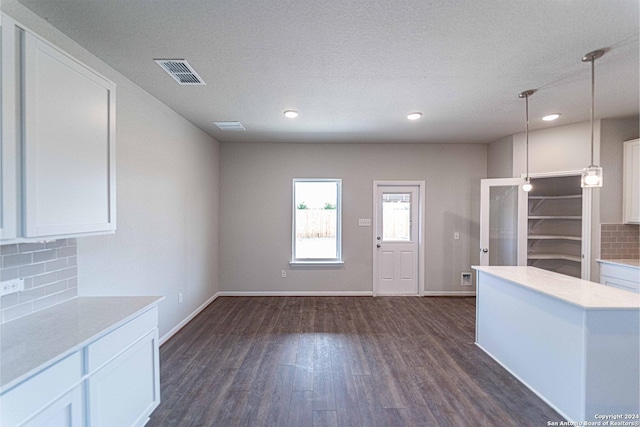 kitchen with backsplash, white cabinets, pendant lighting, and dark hardwood / wood-style floors