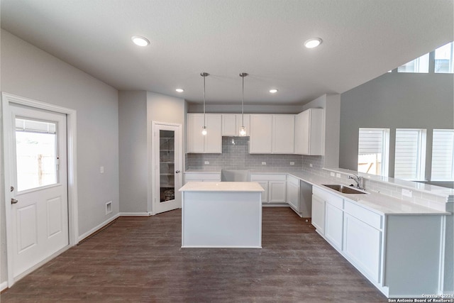 kitchen with white cabinetry, sink, dark hardwood / wood-style floors, pendant lighting, and a kitchen island