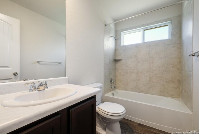 full bathroom featuring wood-type flooring, vanity, toilet, and tiled shower / bath