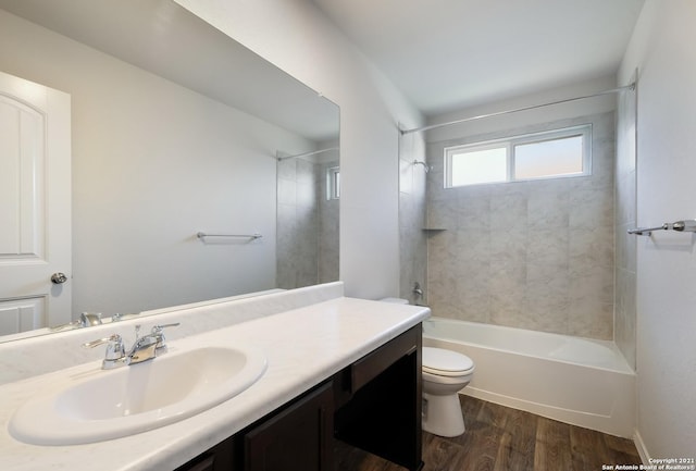 full bathroom with toilet, vanity, tiled shower / bath combo, and hardwood / wood-style flooring